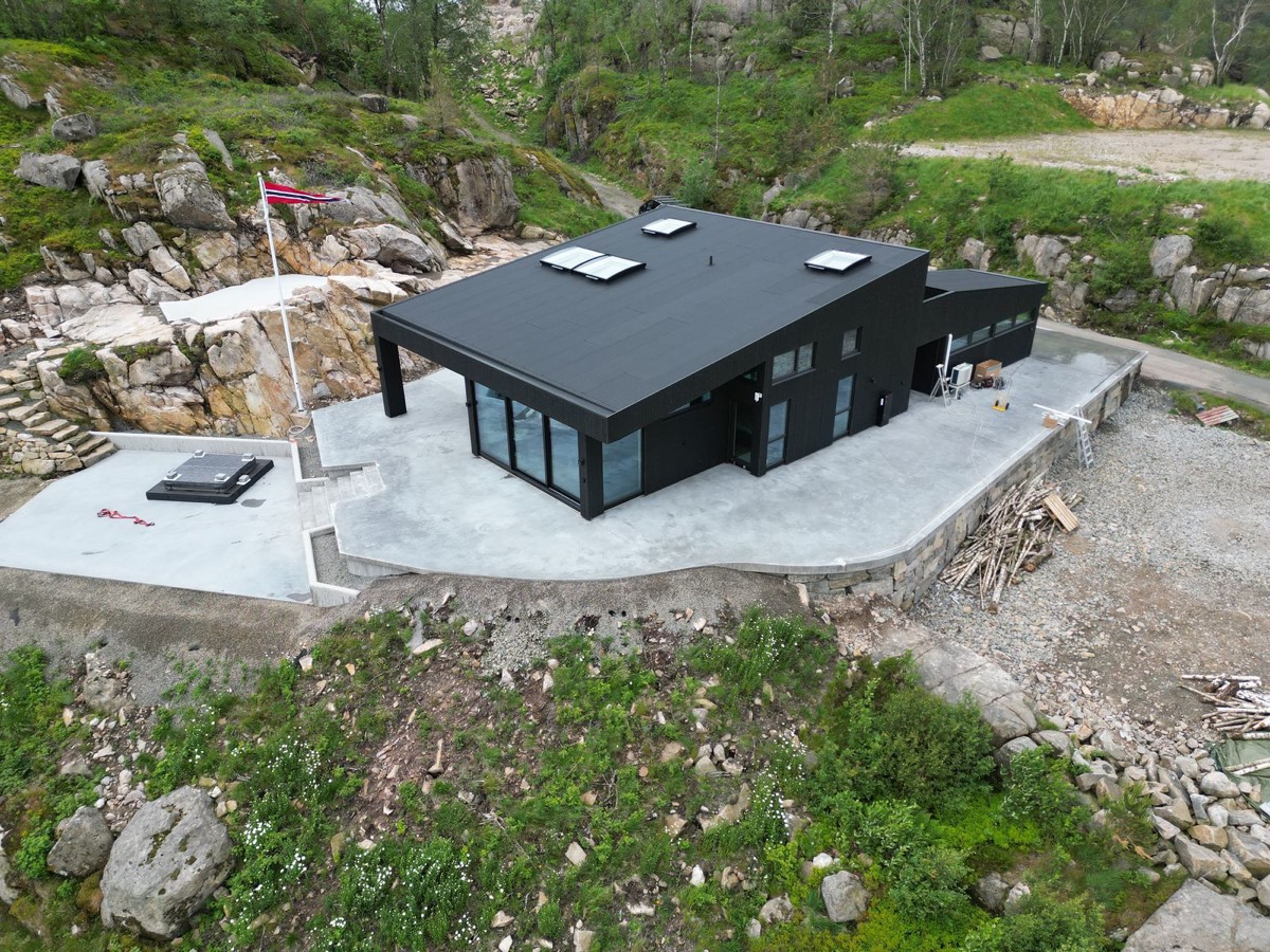 Flyfoto av opparbeidet uteområde rundt en moderne bolig i Lister.